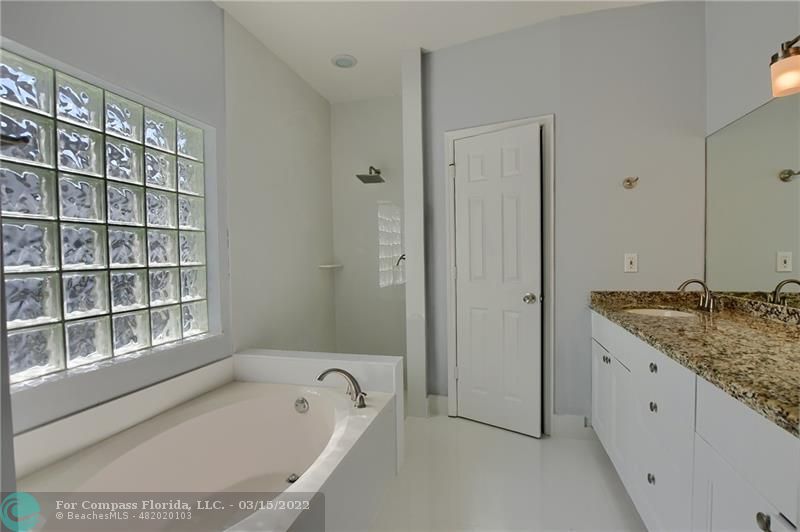 Boca Falls Boca Raton, FL 33428 - Photo 27 of 40 a bathroom with a granite countertop tub and a sink