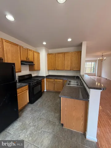 a kitchen with granite countertop a stove top oven sink and cabinets