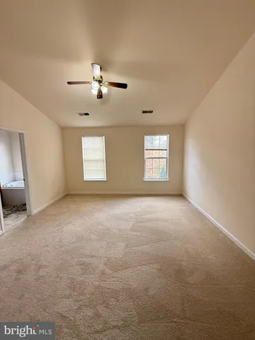 a view of a bedroom with window and ceiling fan