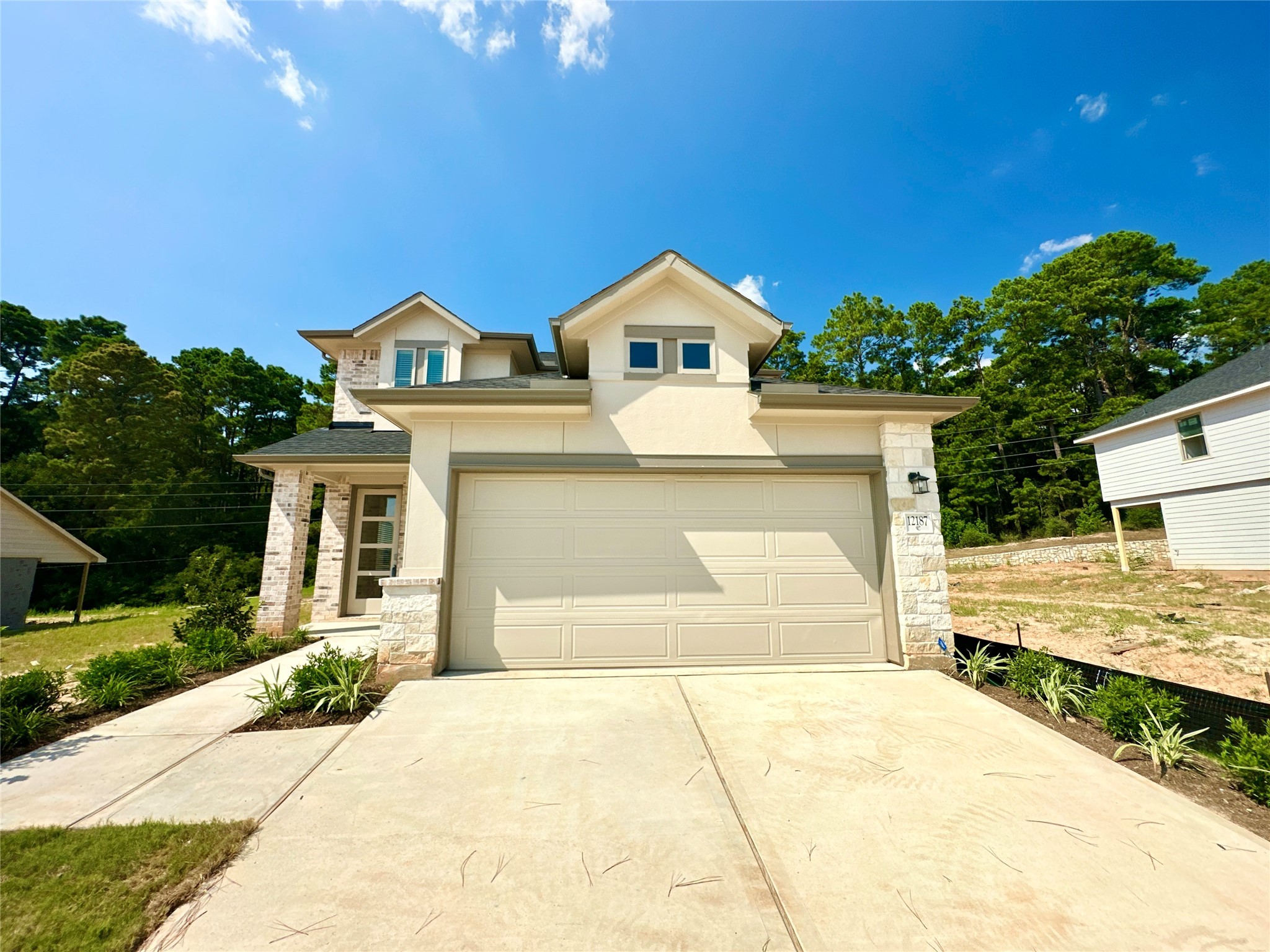 12187 Ridge Top Drive Conroe, TX 77304 - Photo 1 of 26 a front view of a house with a yard and garage