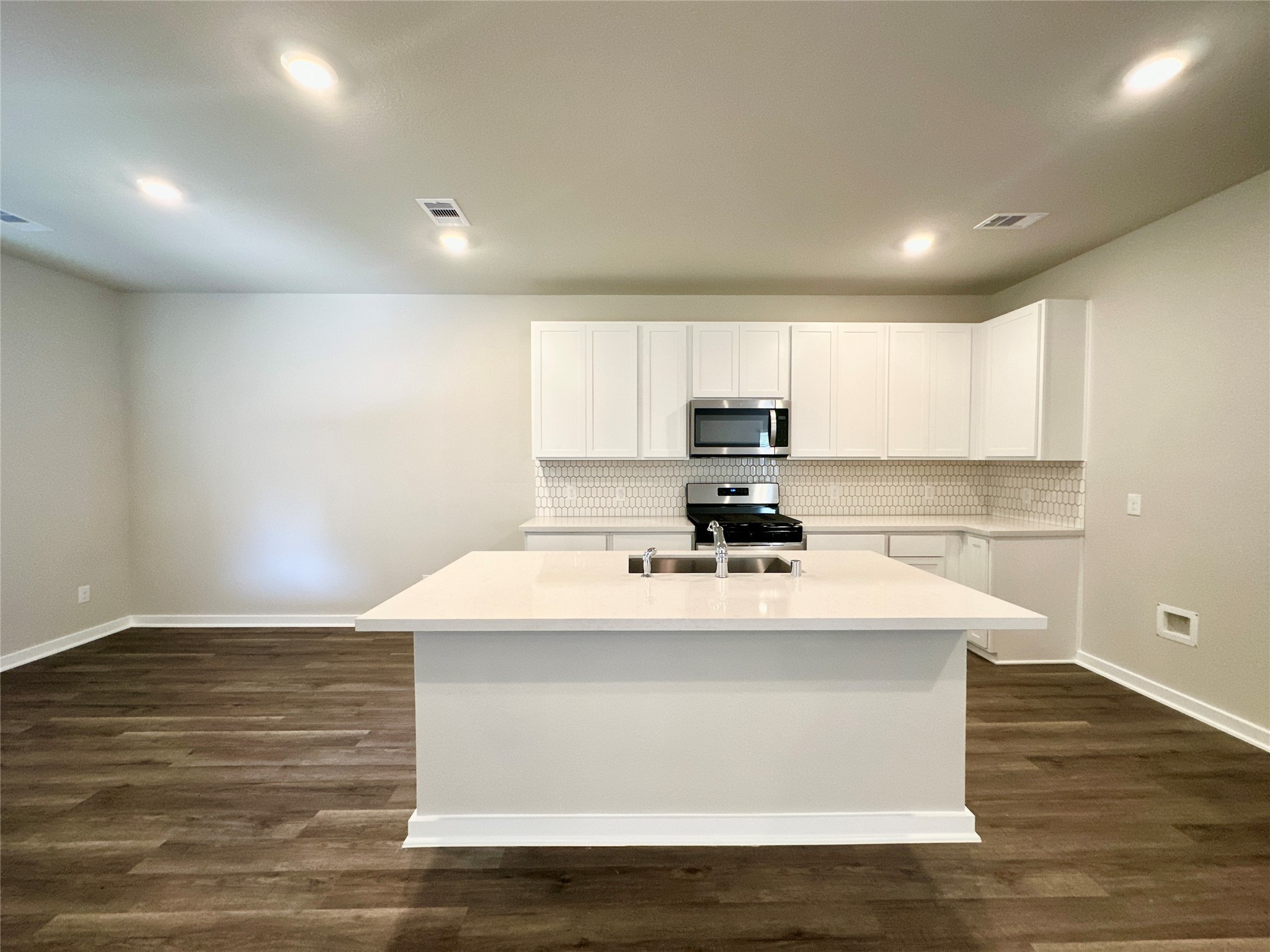 12187 Ridge Top Drive Conroe, TX 77304 - Photo 5 of 26 a kitchen with kitchen island a sink a stove a refrigerator and white cabinets