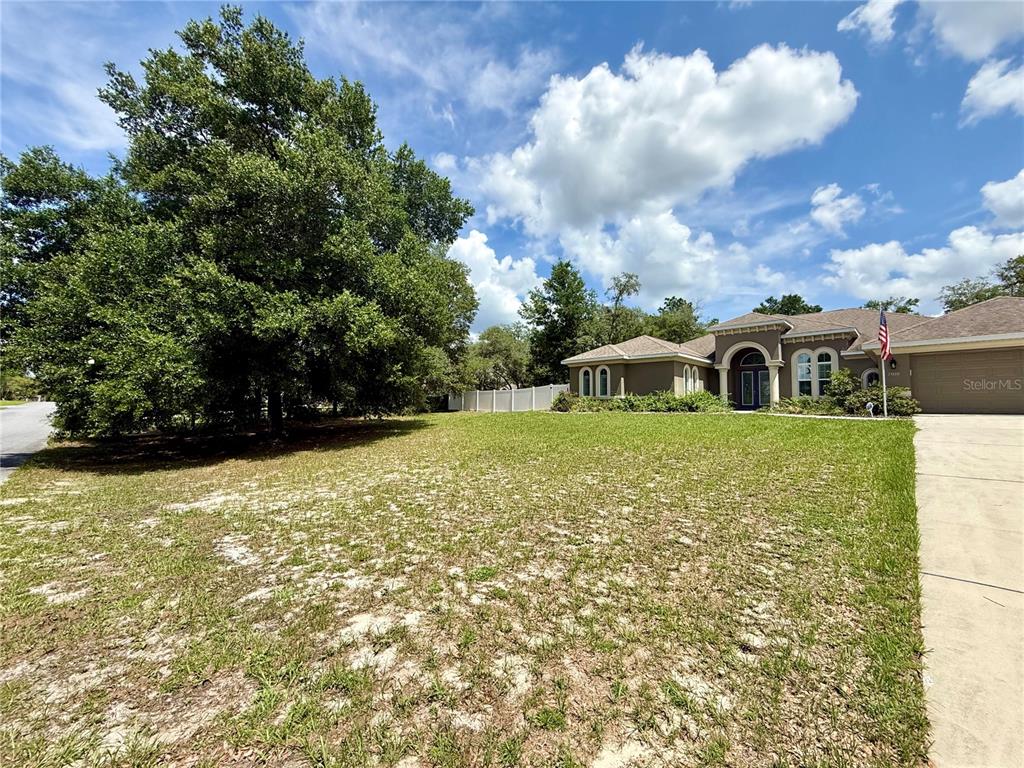 13110 Bamboo Street Spring Hill, FL 34609 - Photo 3 of 56 a front view of a house with a yard