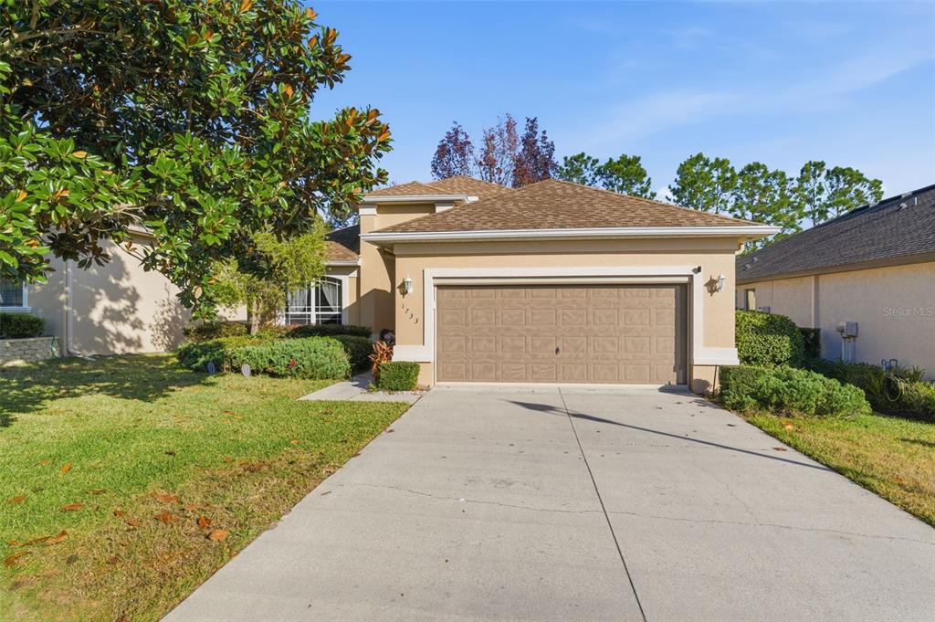 1733 West Caroline Path Lecanto, FL 34461 - Photo 2 of 29 a front view of a house with a yard and garage