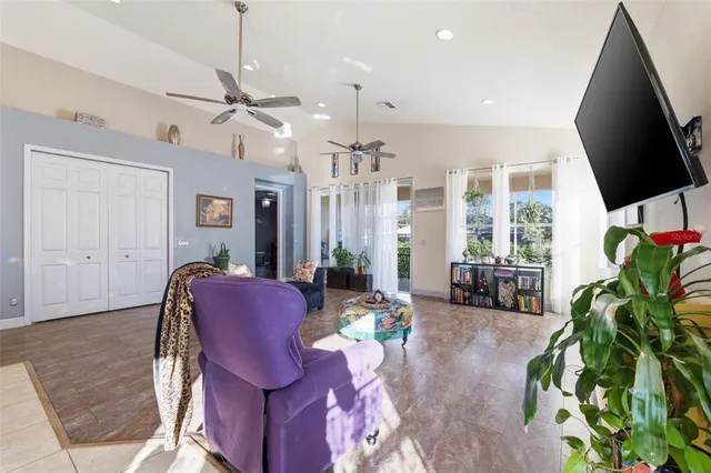 a living room with furniture a chandelier and a flat screen tv