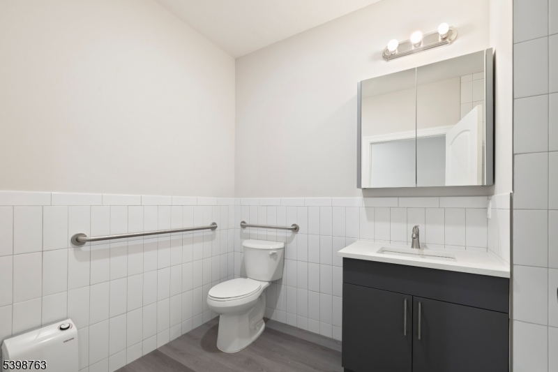 60 Woodside Place, Unit 4C Newark, NJ 07104 - Photo 12 of 14 a bathroom with a toilet sink and mirror