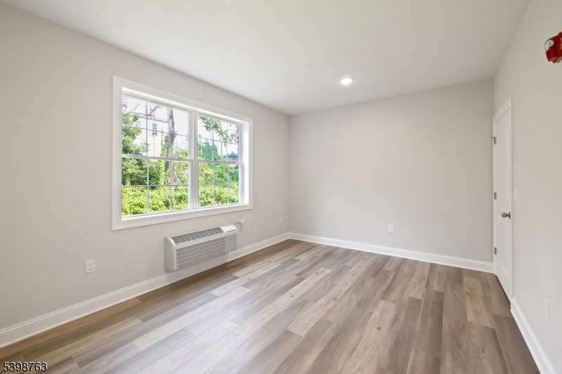 60 Woodside Place, Unit 4C Newark, NJ 07104 - Photo 10 of 14 wooden floor in an empty room with a window
