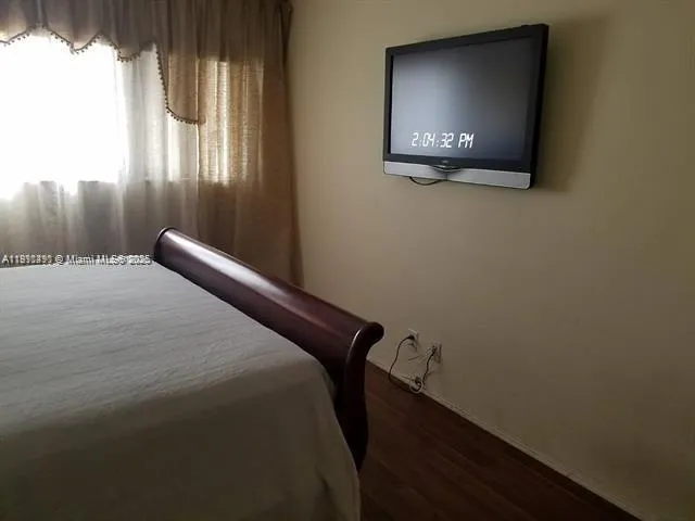 a bedroom with a bed and a television
