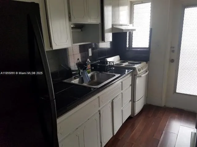 a kitchen with a sink stove and cabinets