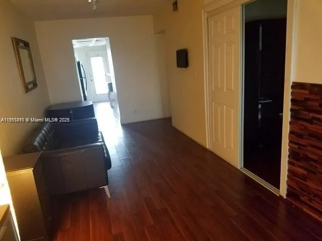 a view of a hallway with wooden floor and stairs