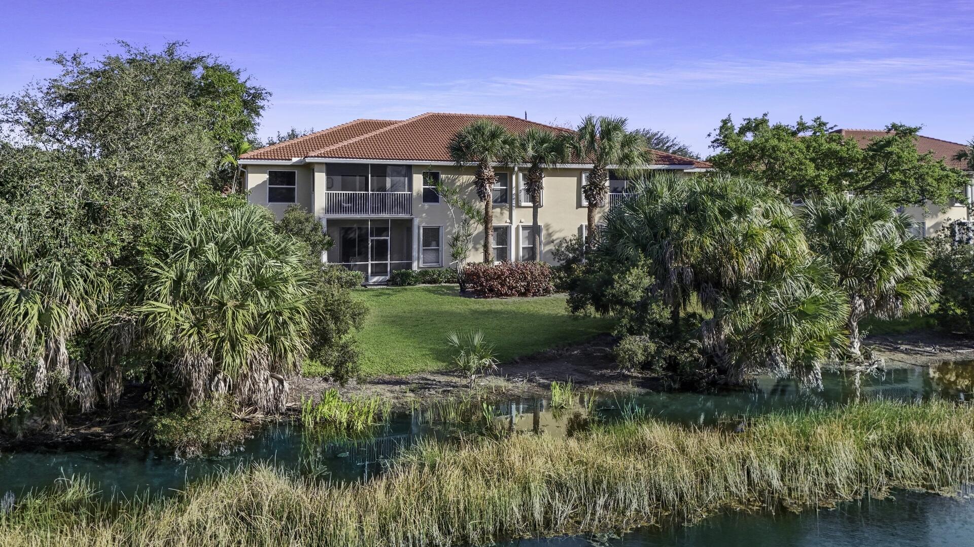 12438 Crystal Pointe Drive, Unit 102 Boynton Beach, FL 33437 - Photo 28 of 39 a view of a house with a yard and a pond