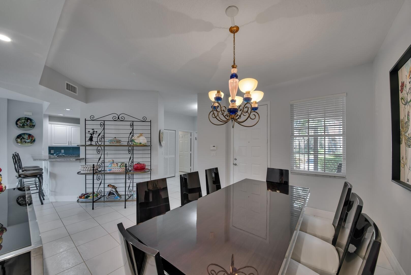 12438 Crystal Pointe Drive, Unit 102 Boynton Beach, FL 33437 - Photo 39 of 39 a view of a dining room and a livingroom with furniture wooden floor a chandelier