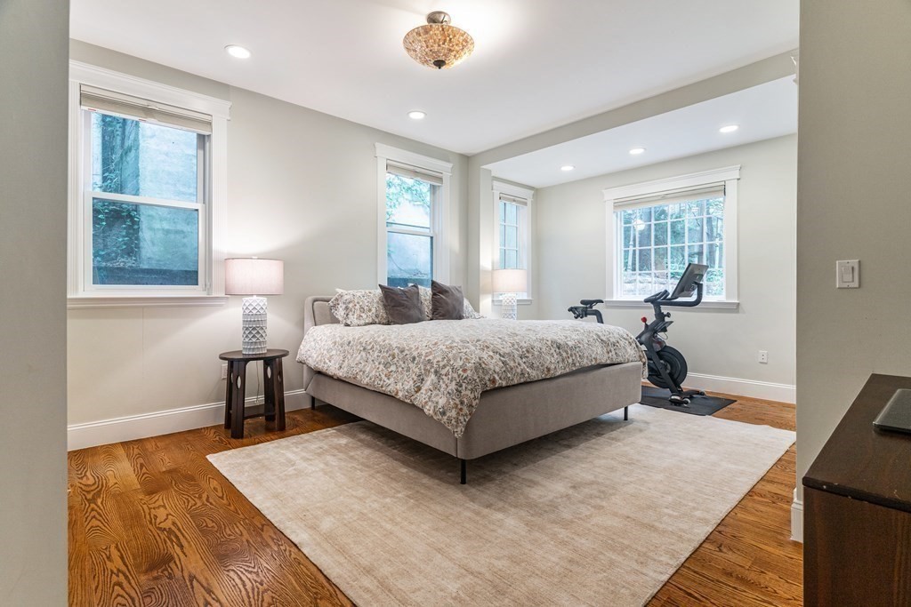 91 University Road, Unit 1 Brookline, MA 02445 - Photo 16 of 39 a bedroom with a bed wooden floor and a table