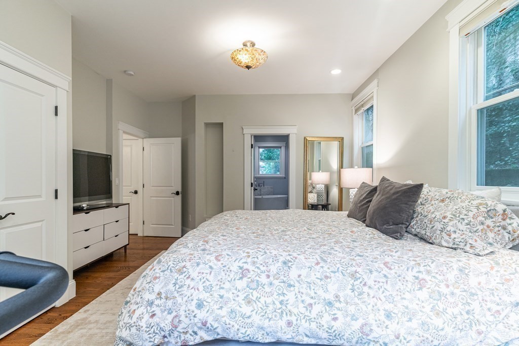91 University Road, Unit 1 Brookline, MA 02445 - Photo 17 of 39 a bedroom with a large bed and a flat tv screen on dresser