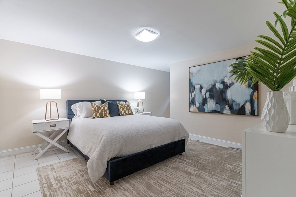 91 University Road, Unit 1 Brookline, MA 02445 - Photo 27 of 39 a bedroom with a large bed and a potted plant