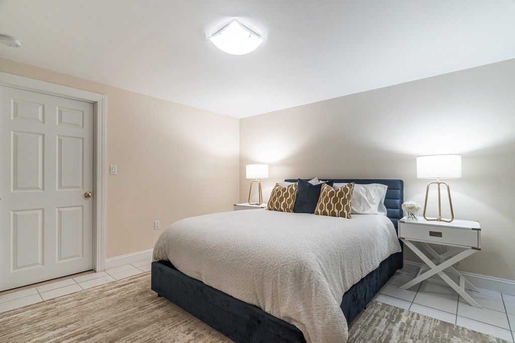 91 University Road, Unit 1 Brookline, MA 02445 - Photo 28 of 39 a bedroom with a bed and wooden floor