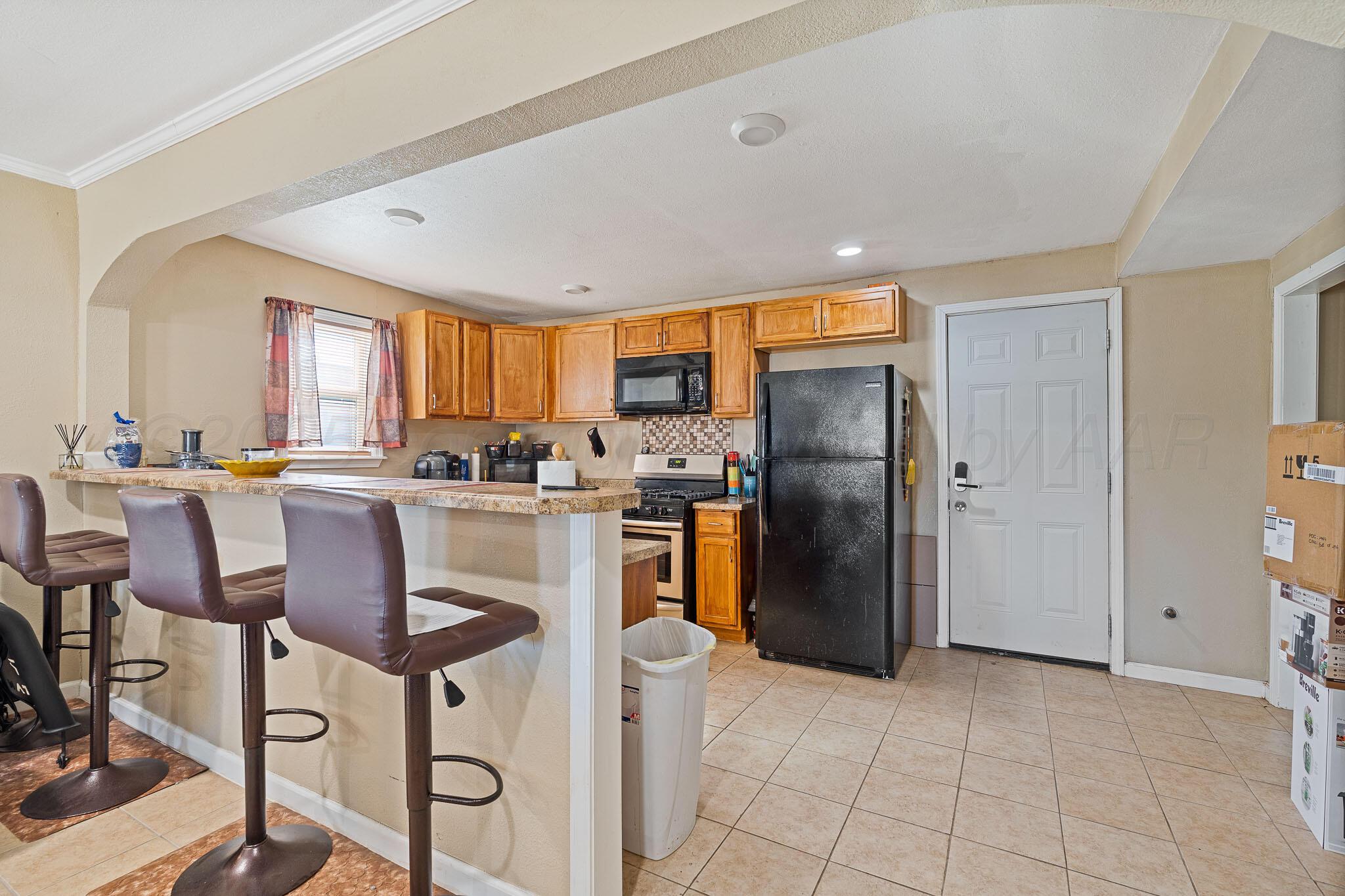 702 South Cleveland Street Amarillo, TX 79102 - Photo 5 of 11 a kitchen with stainless steel appliances granite countertop a refrigerator and a stove top oven