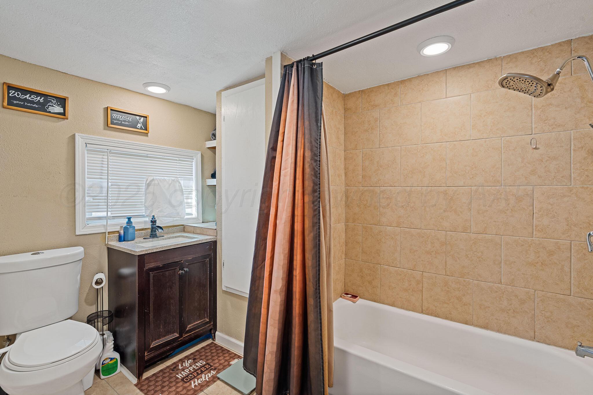 702 South Cleveland Street Amarillo, TX 79102 - Photo 8 of 11 a bathroom with a sink a toilet and shower