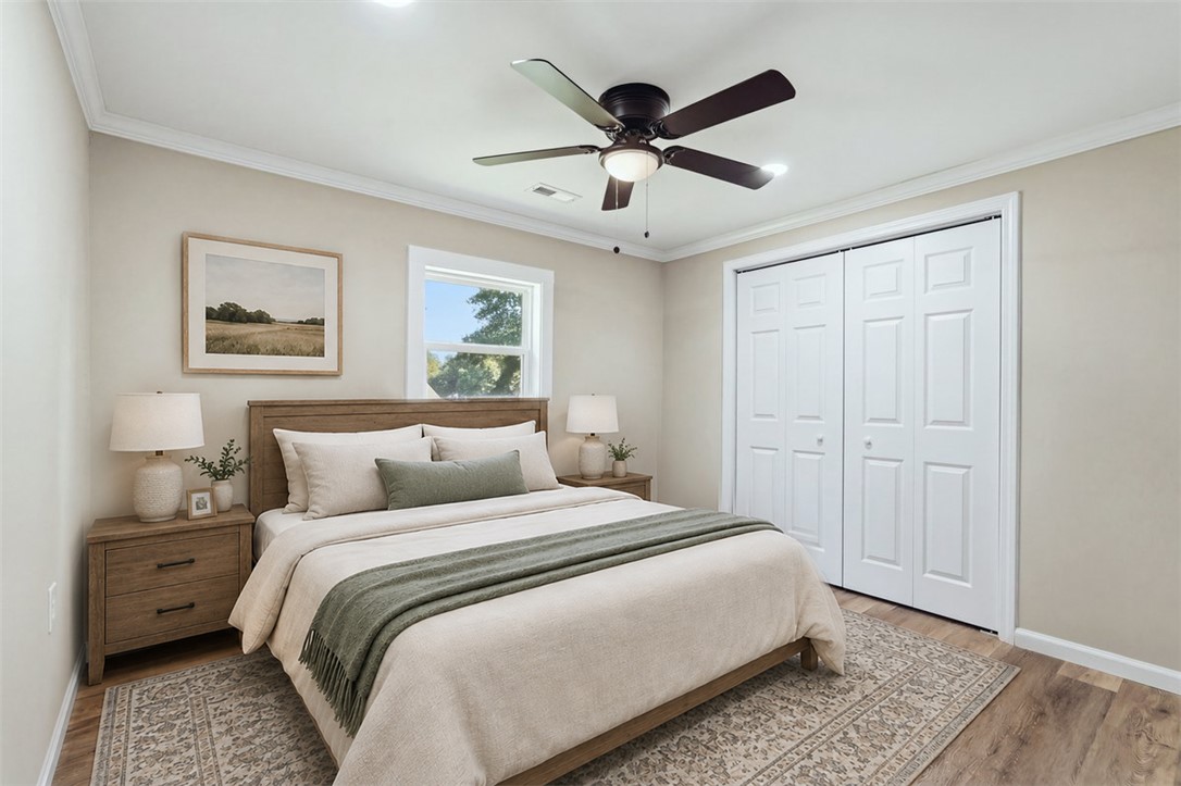 418 Old River Road Pelzer, SC 29669 - Photo 19 of 32 Rich wood floors and elegant crown molding elevate this serene and comfortable bedroom space.
