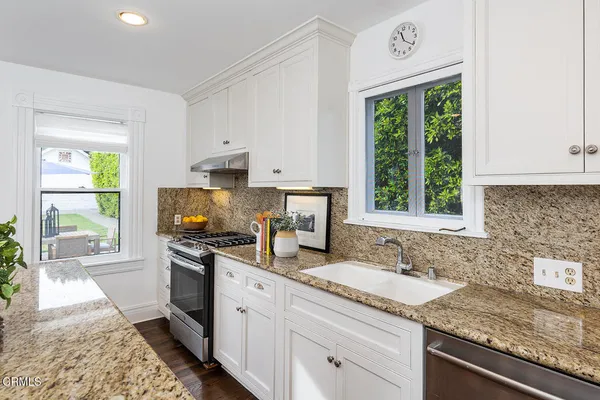 a kitchen with kitchen island granite countertop a sink a counter top space and cabinets