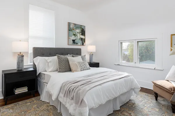 a bedroom with a bed a dresser and window