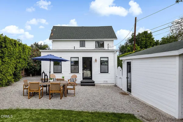 a view of a patio with table and chairs under an umbrella