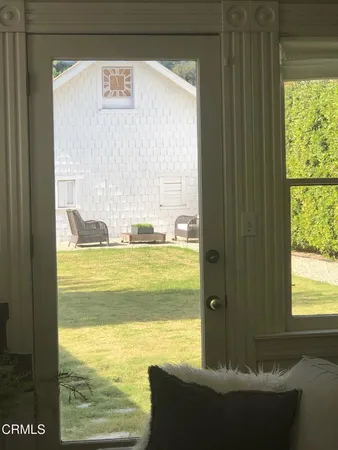 a view of a chair and table in backyard of the house