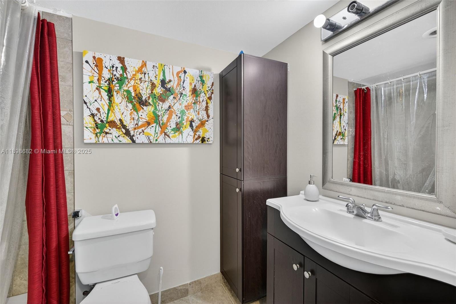 3821 Environ Boulevard, Unit 411 Lauderhill, FL 33319 - Photo 14 of 62 a bathroom with a sink a toilet and a mirror