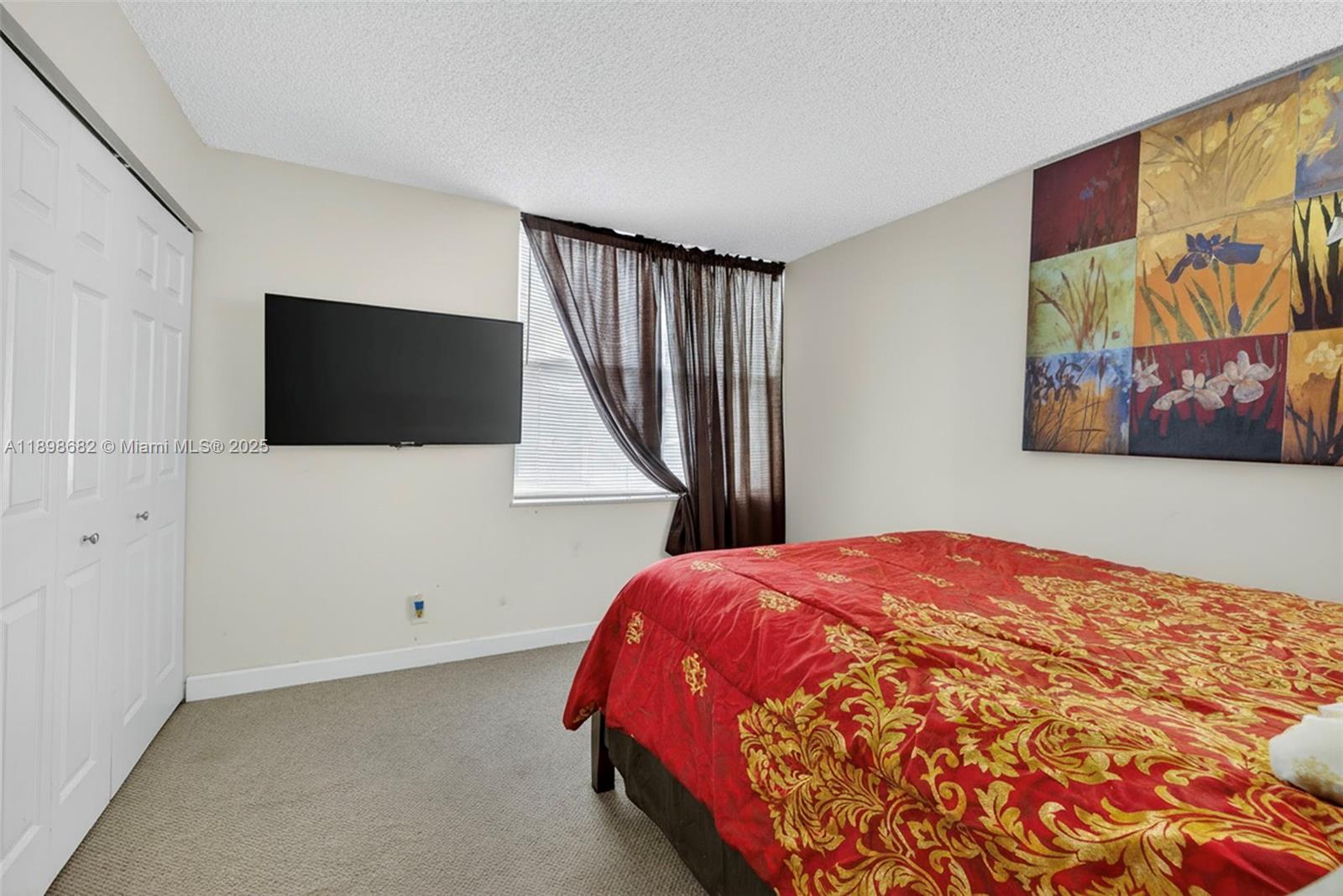3821 Environ Boulevard, Unit 411 Lauderhill, FL 33319 - Photo 15 of 62 a bedroom with a bed and a flat screen tv