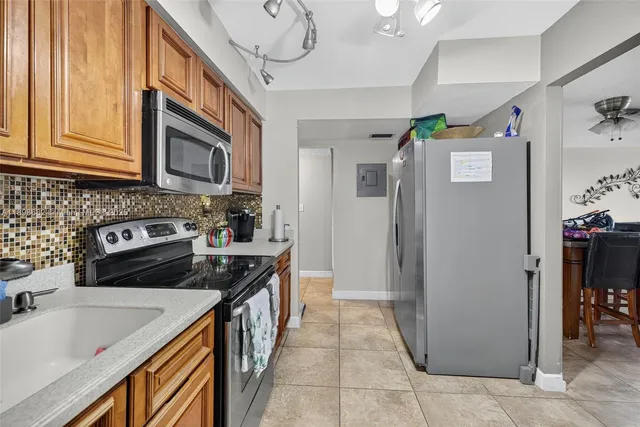 a kitchen with stainless steel appliances granite countertop a refrigerator a stove and a sink with cabinets