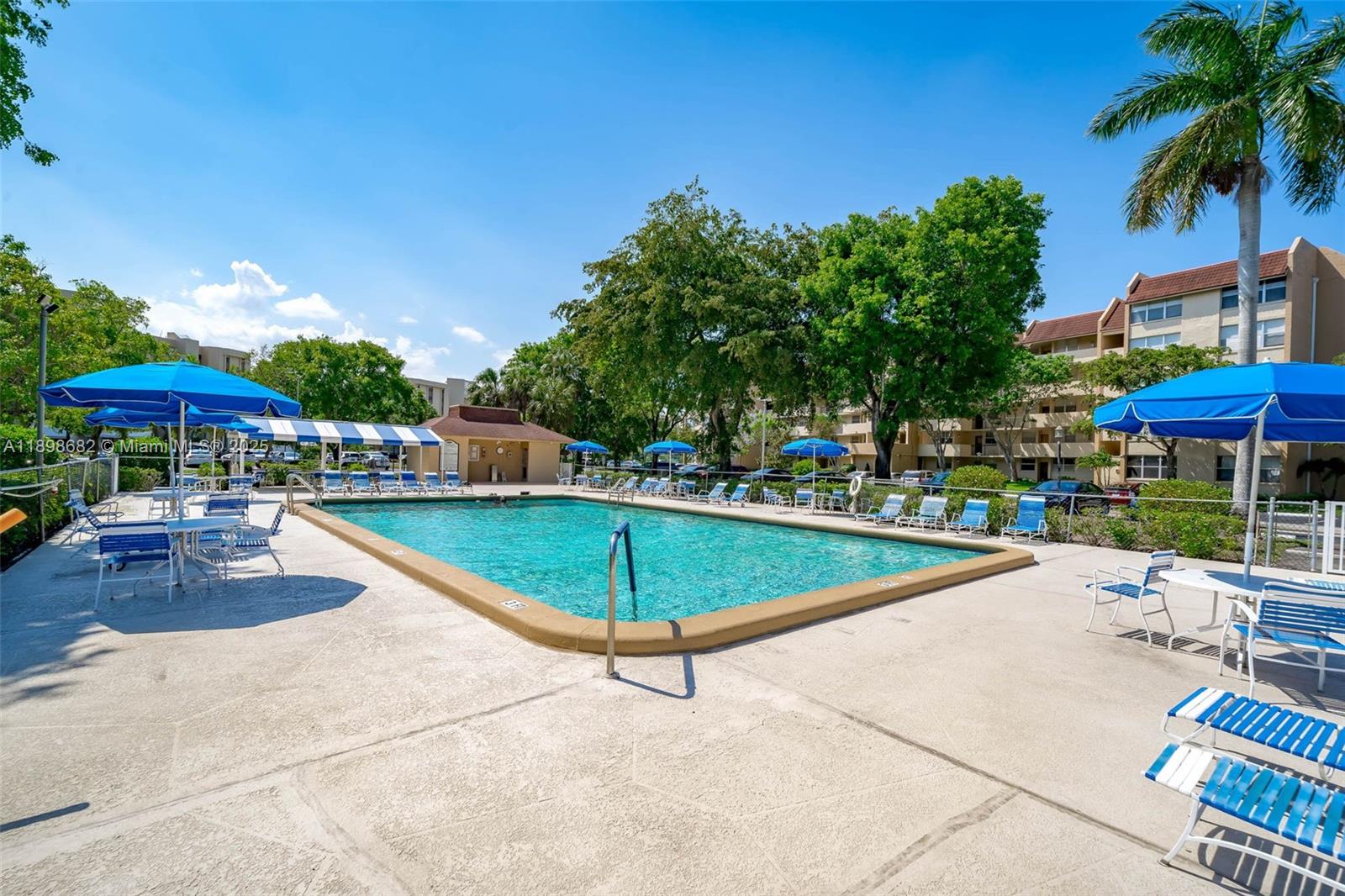 3821 Environ Boulevard, Unit 411 Lauderhill, FL 33319 - Photo 40 of 62 a view of a swimming pool with a table and chairs under an umbrella