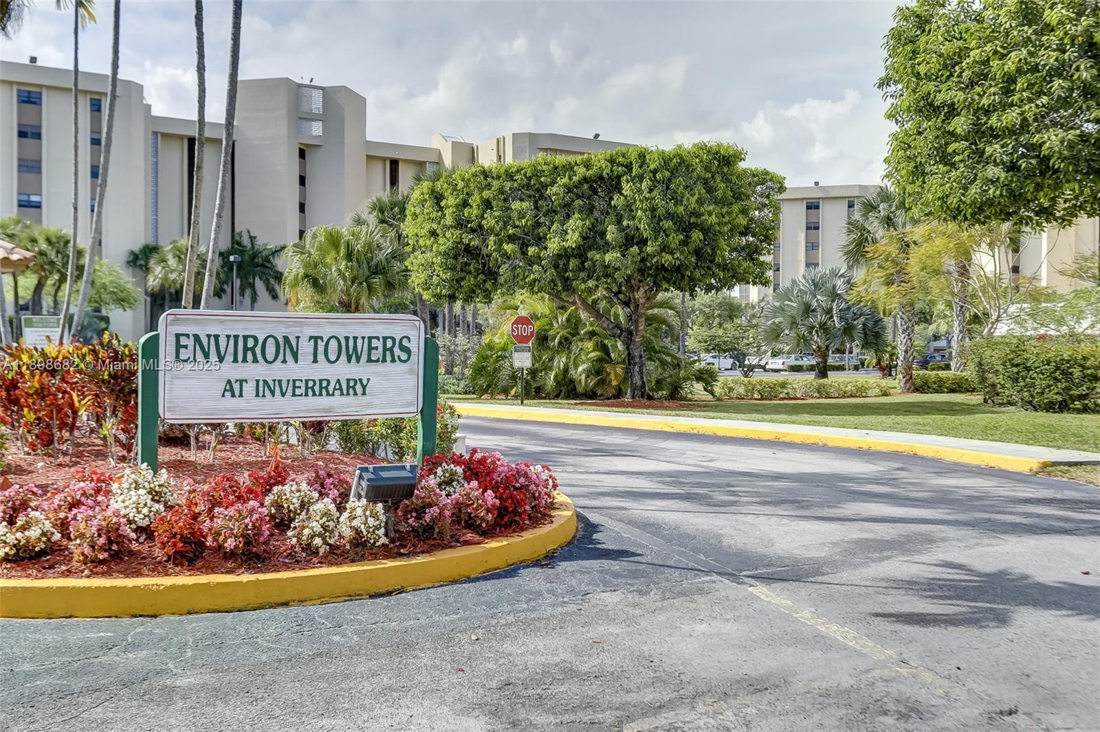 3821 Environ Boulevard, Unit 411 Lauderhill, FL 33319 - Photo 41 of 62 a view of a sign board with flower plants and wooden fence