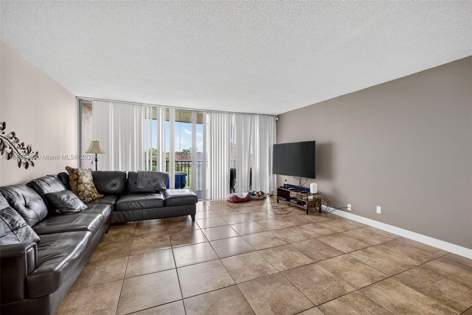 3821 Environ Boulevard, Unit 411 Lauderhill, FL 33319 - Photo 6 of 62 a living room with furniture and a flat screen tv