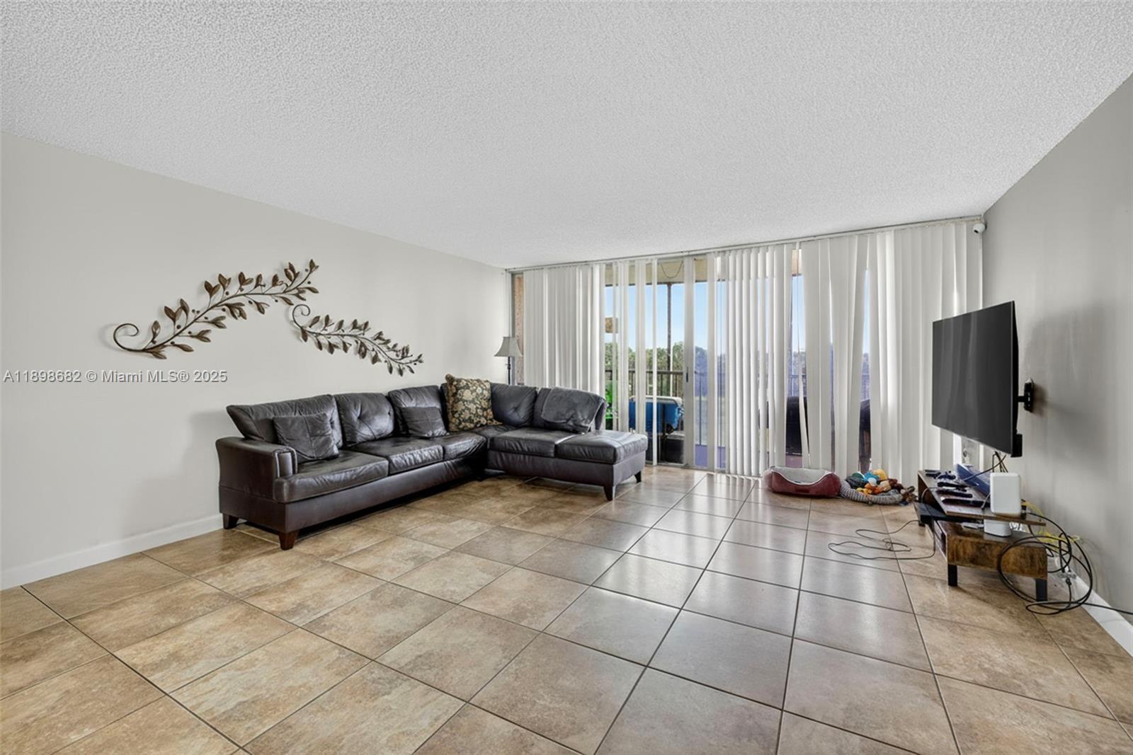 3821 Environ Boulevard, Unit 411 Lauderhill, FL 33319 - Photo 7 of 62 a living room with furniture and a flat screen tv