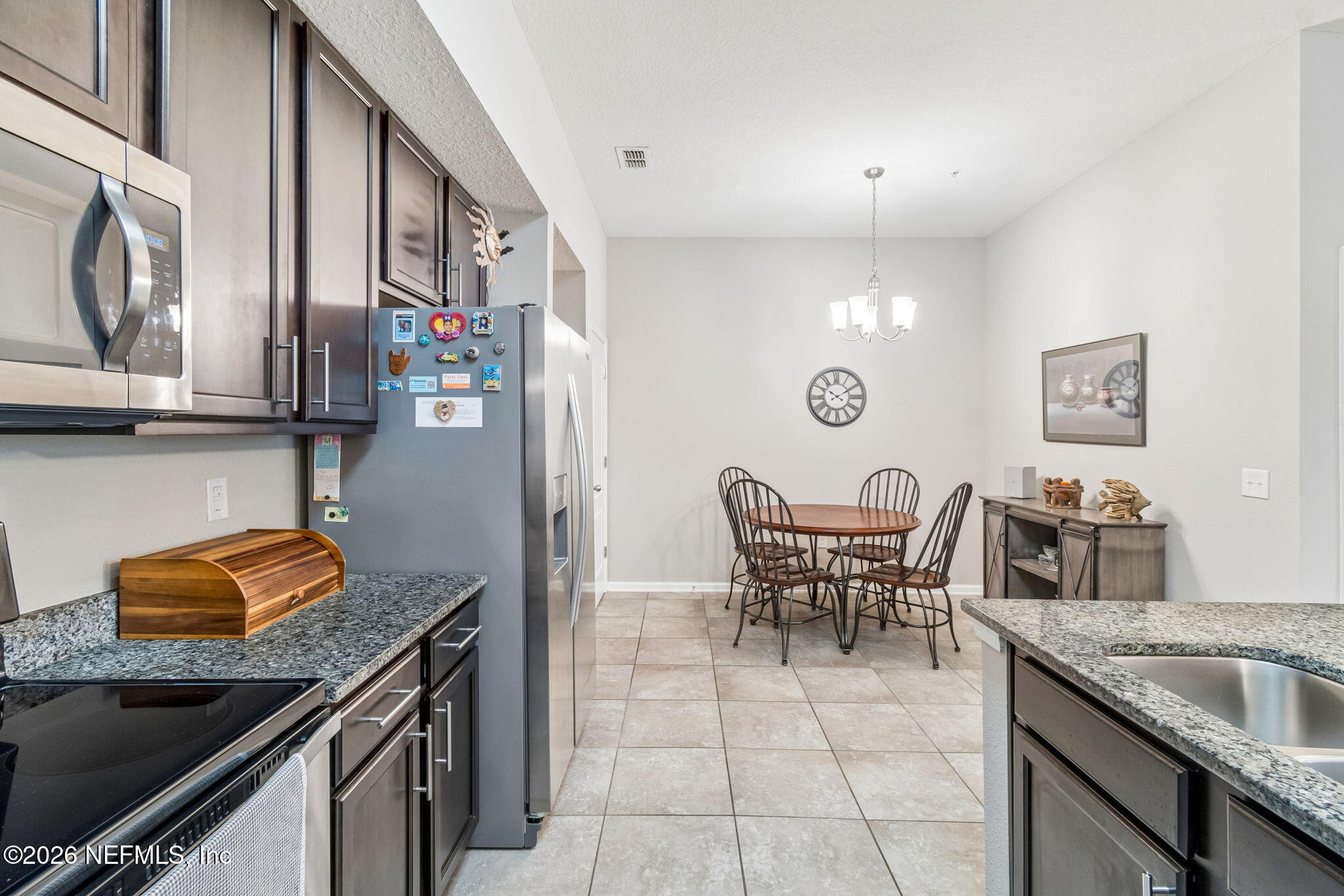 2113 Golden Lake Loop St. Augustine, FL 32084 - Photo 22 of 50 a kitchen with stainless steel appliances granite countertop a stove top oven a sink a dining table and chairs with wooden floor