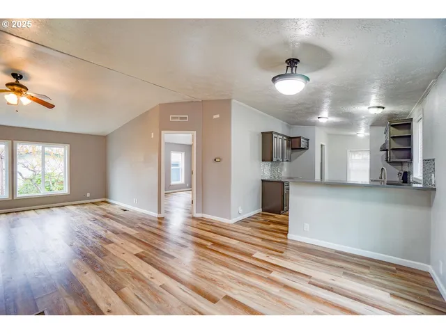 a view of a kitchen with wooden floor and a ceiling fan
