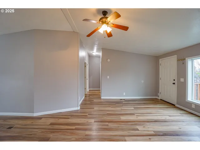 a view of an empty room with wooden floor