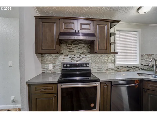a kitchen with granite countertop a stove sink and cabinets