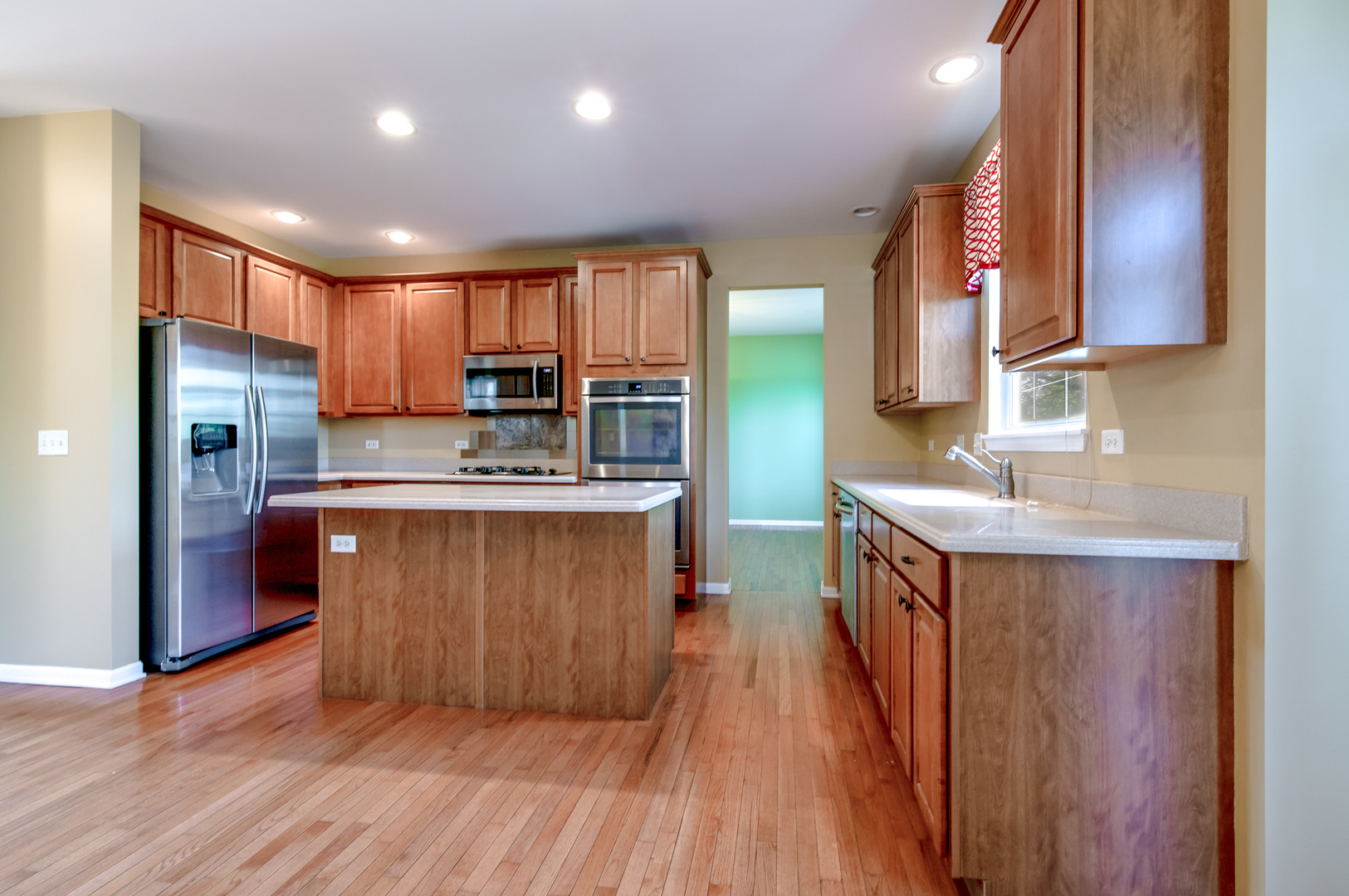 860 Spring Creek Circle Naperville, IL 60565 - Photo 8 of 26 a kitchen with kitchen island granite countertop wooden floors wooden cabinets a sink and appliances