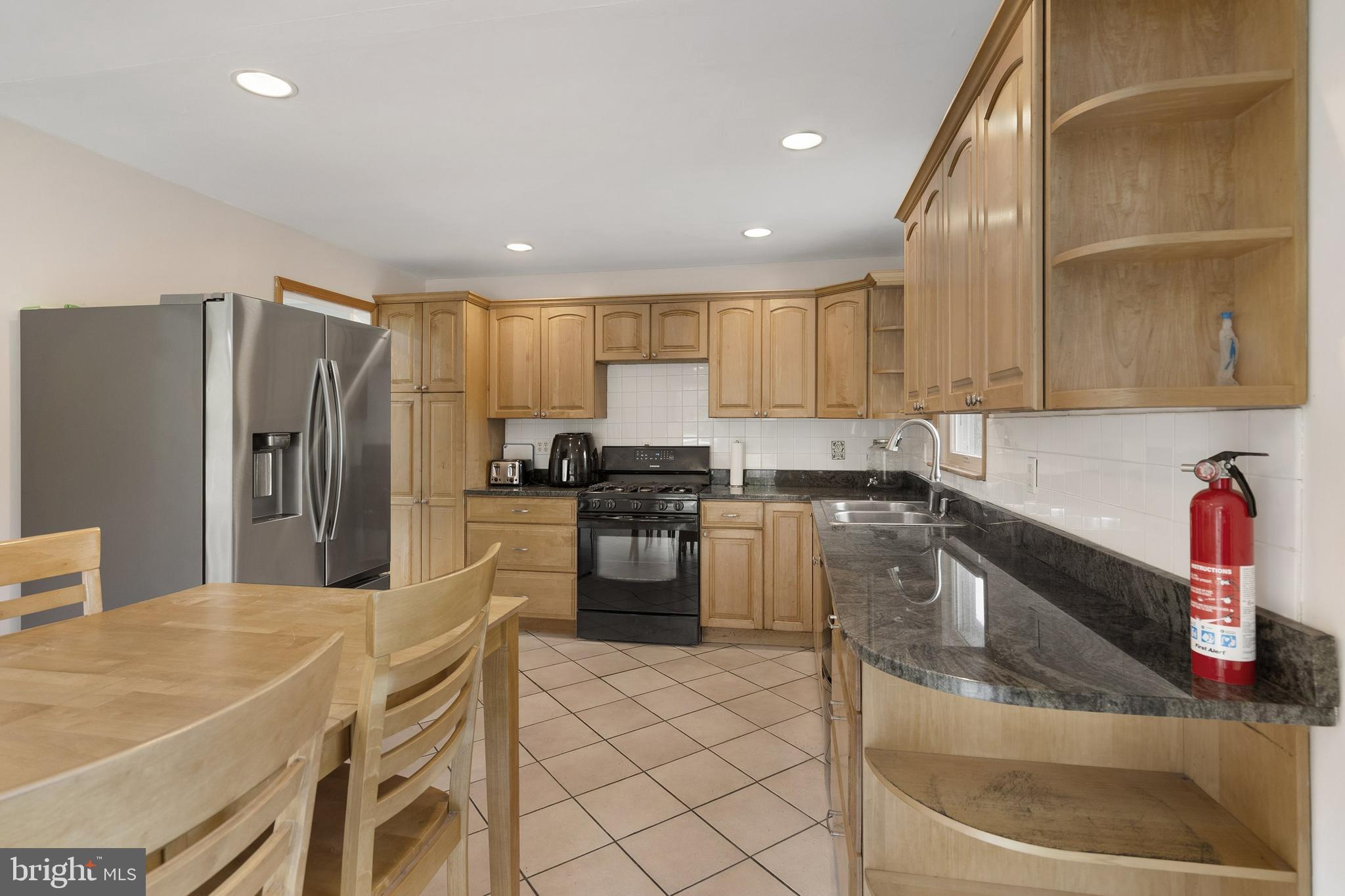 86 Bunting Bridge Road Cookstown, NJ 08511 - Photo 8 of 36 a kitchen with granite countertop a refrigerator a sink a stove a dining table and chairs