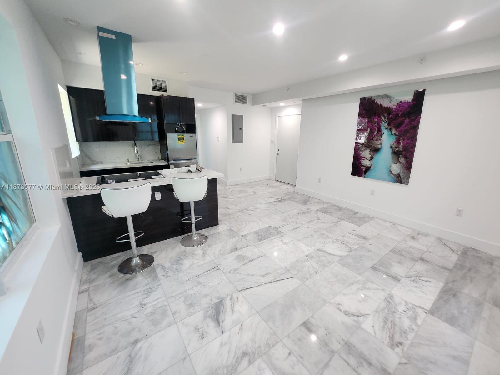 1560 Drexel Avenue, Unit 207 Miami Beach, FL 33139 - Photo 1 of 12 a room with gym equipment and a flat screen tv