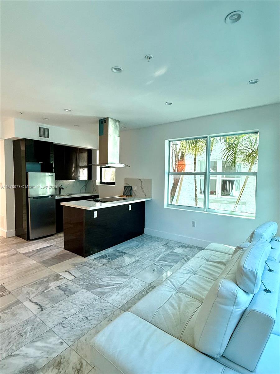 1560 Drexel Avenue, Unit 207 Miami Beach, FL 33139 - Photo 3 of 12 a living room with a large window and kitchen view