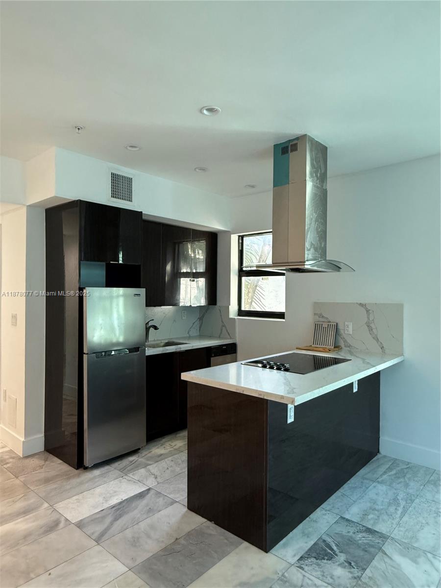 1560 Drexel Avenue, Unit 207 Miami Beach, FL 33139 - Photo 4 of 12 a kitchen with a sink and stainless steel appliances