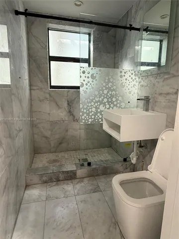 a bathroom with a toilet sink and mirror