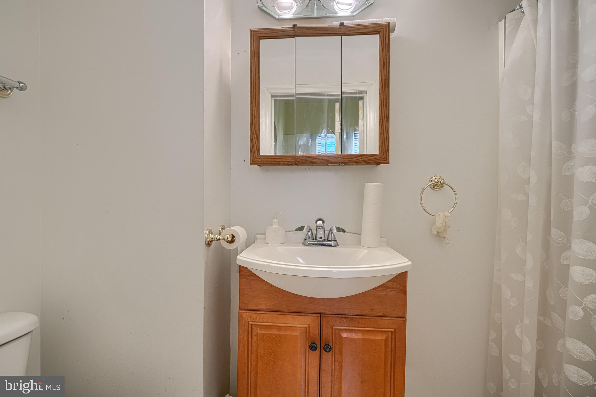 3212 Dorchester Road Baltimore, MD 21215 - Photo 18 of 45 a bathroom with a sink and a mirror
