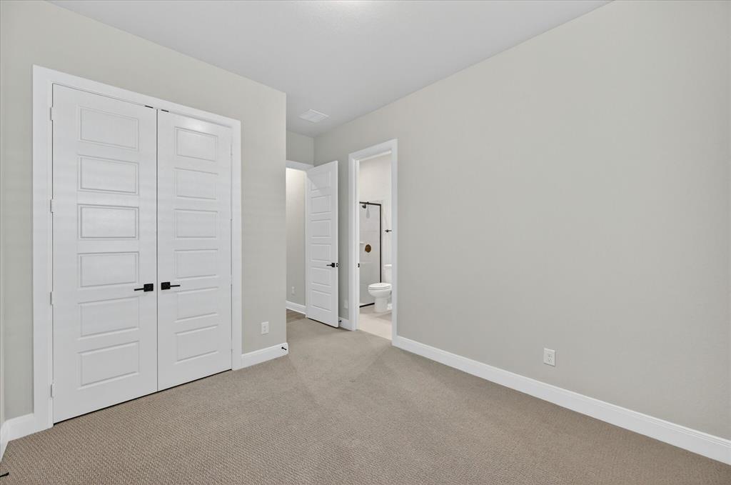 2237 Pika Road Northlake, TX 76247 - Photo 34 of 37 Neutral toned room with plush carpeting, featuring white paneled double doors with matte black hardware