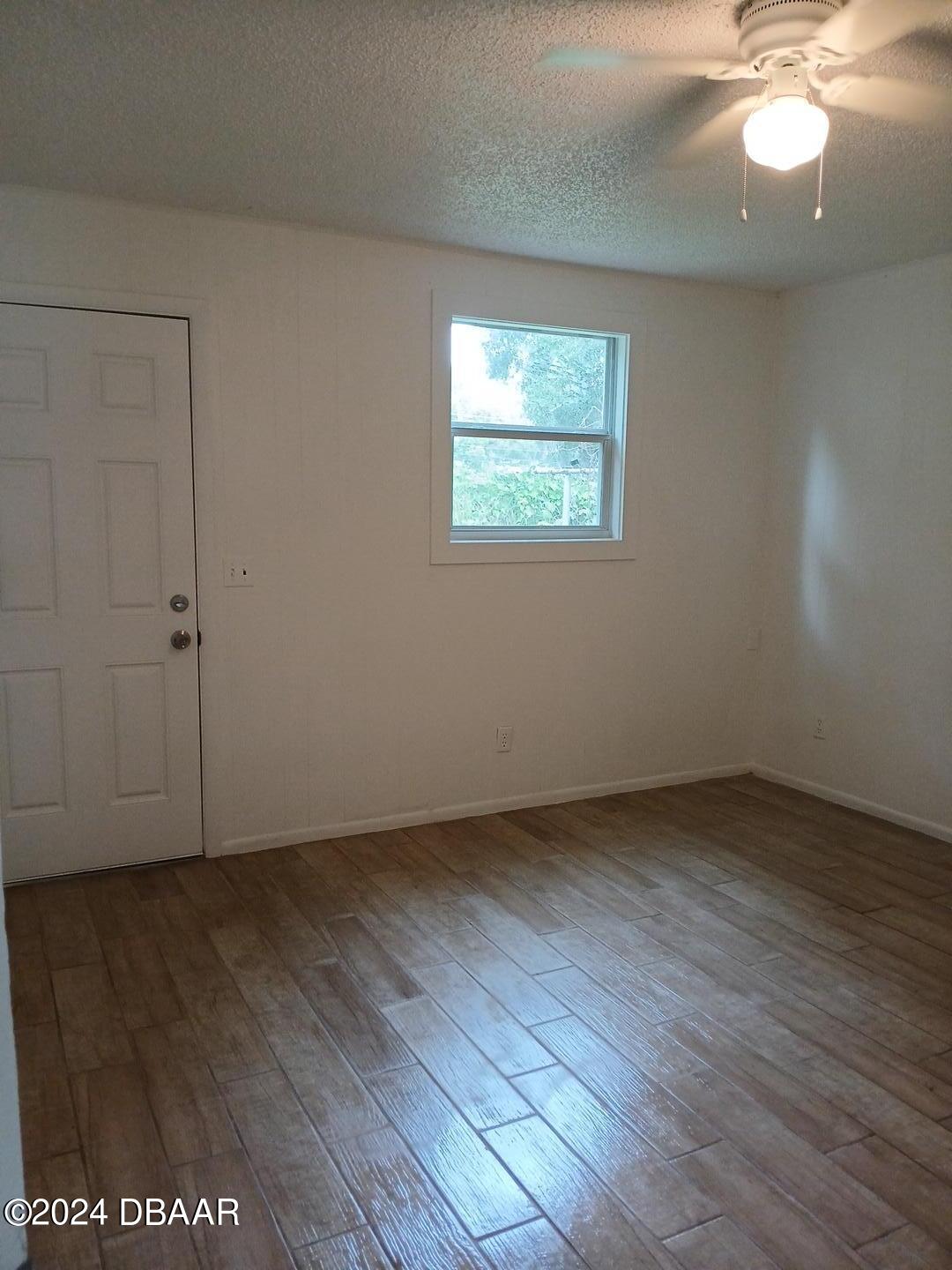 232 Summit Street Crescent City, FL 32112 - Photo 9 of 12 an empty room with wooden floor and windows