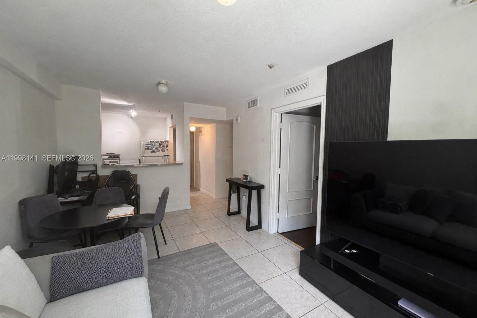 2536 Northwest 24th Street, Unit 3F Miami, FL 33142 - Photo 11 of 17 a living room with furniture and a flat screen tv