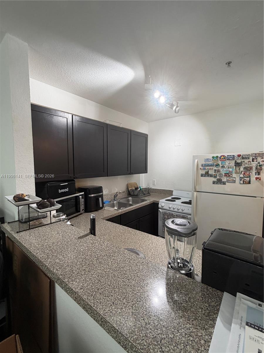 2536 Northwest 24th Street, Unit 3F Miami, FL 33142 - Photo 12 of 17 a kitchen with stainless steel appliances kitchen island granite countertop a sink and a stove