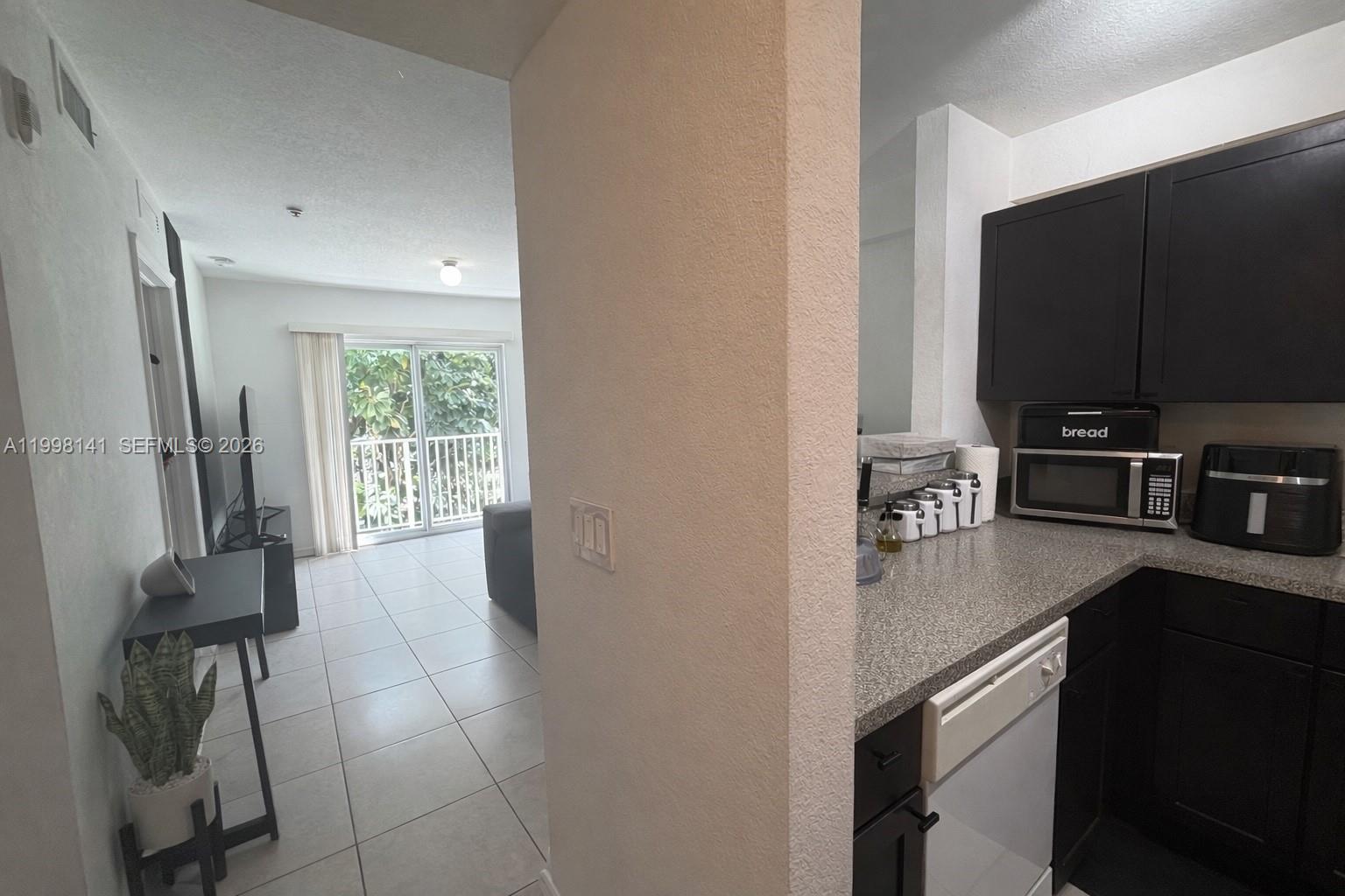 2536 Northwest 24th Street, Unit 3F Miami, FL 33142 - Photo 5 of 17 a kitchen with stainless steel appliances a sink stove and refrigerator