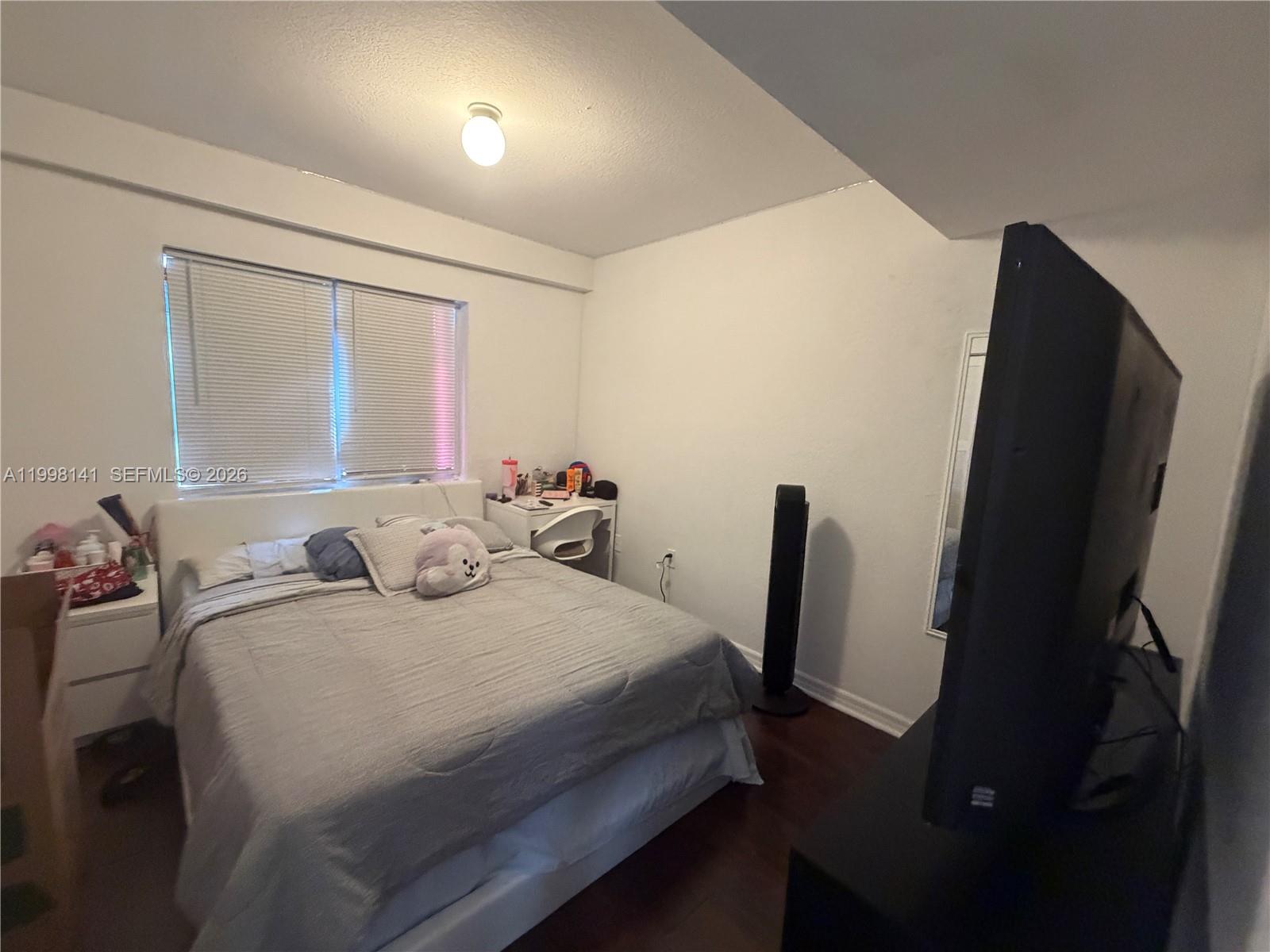 2536 Northwest 24th Street, Unit 3F Miami, FL 33142 - Photo 6 of 17 a bedroom with a bed tv and a window
